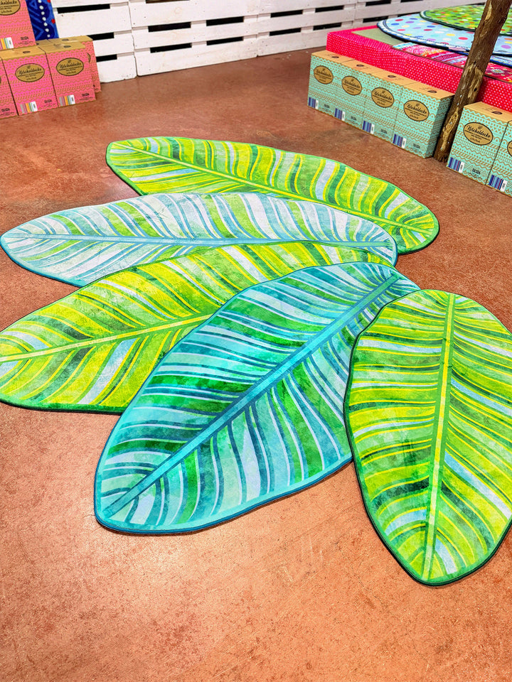 Superweicher Teppich im Design von Bine Brändle in Form eines Bananenblatts mit Motiv in verschiedenen Grüntönen, tropisch und modern gestaltet.